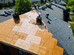 Reflective residential roof under summer sunlight with attic ventilation and mature trees nearby.